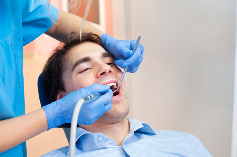 Man receiving dental cleaning from dental hygienist at Masci, Hale & Wilson Advanced Aesthetic and Restorative Dentistry in Montgomery, NY