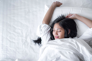 Woman lying in bed and stretching