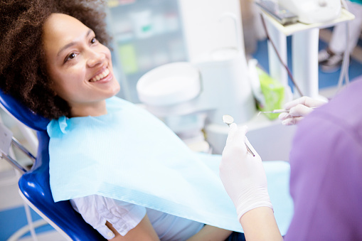 Smiling woman in dental chair looking up at dental assistant at Masci, Hale & Wilson Advanced Aesthetic and Restorative Dentistry in Montgomery, NY