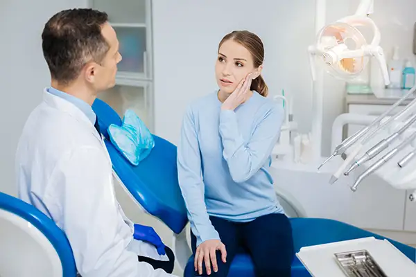 Concerned patient discussing her tooth pain with her dentist while sitting in a dental chair at Masci, Hale & Wilson Advanced Aesthetic and Restorative Dentistry.
