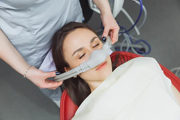 Image of a woman getting a sedation mask placed.